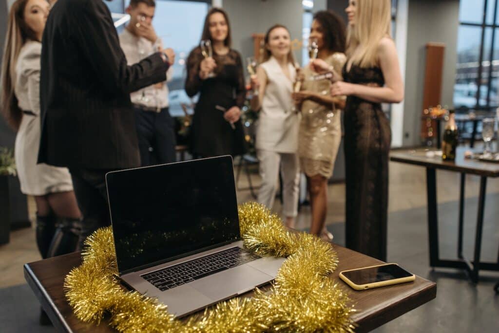 Photo by Pavel Danilyuk: https://www.pexels.com/photo/group-of-people-holding-wine-glasses-standing-near-a-table-with-laptop-6405674/ -- office party