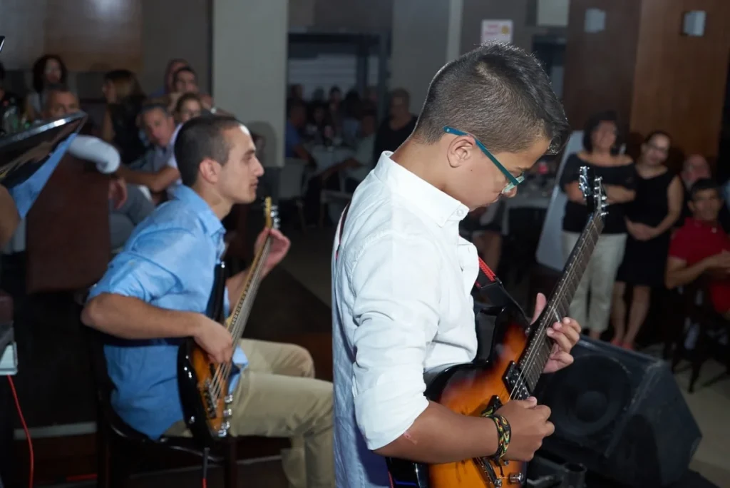Image Title: Bar Mitzvah New York Alt Text: Boys playing guitar during bar mitzvah event. Source: https://pixabay.com/photos/guitar-show-bar-mitzvah-man-boy-1024688/