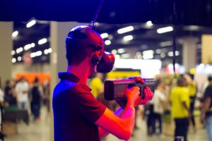  Image Title: AR Experience in Action Image Description: A person immersed in augmented reality gameplay at a bustling event Alt Text: Man in headset exploring augmented reality at a vibrant expo Source: https://www.pexels.com/photo/man-in-vr-headset-in-modern-club-3907022/