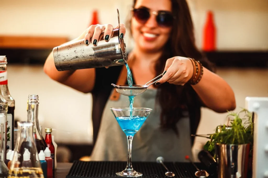 Photo by Helena Lopes: https://www.pexels.com/photo/crop-cheerful-woman-preparing-homemade-blue-cocktail-in-bar-4279109/ -- party drinks
