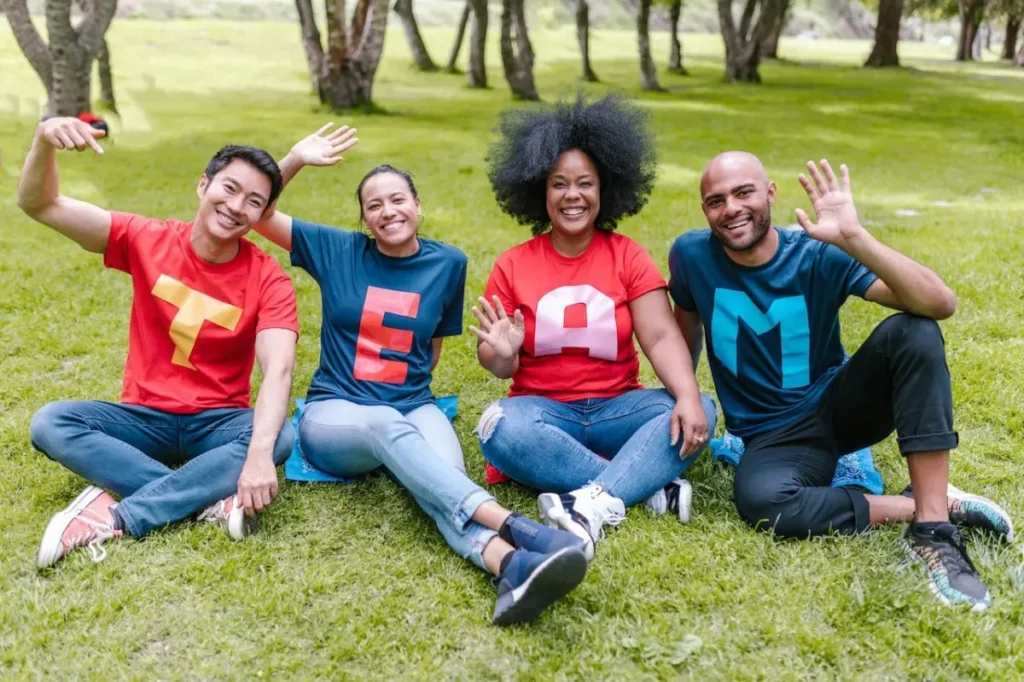 Photo by RDNE Stock project: https://www.pexels.com/photo/people-sitting-on-green-grass-waving-their-hands-7551760/ -- team-building