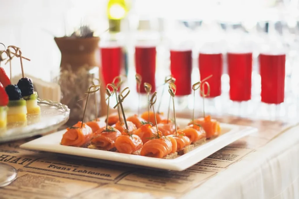 Photo by Tanya Gorelova: https://www.pexels.com/photo/salmon-canapes-and-fruits-on-white-tray-3933162/ -- gourmet appetizers