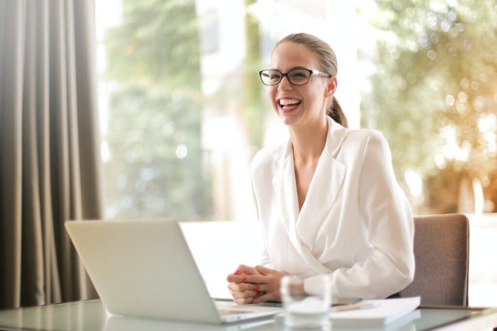 Photo by Andrea Piacquadio: https://www.pexels.com/photo/laughing-businesswoman-working-in-office-with-laptop-3756679/ -- company professional