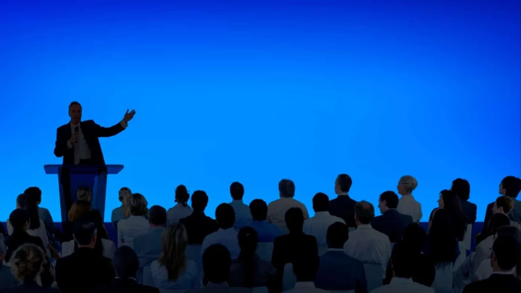 Image Title: Product Launch Presentation Image Description: Presenter at product launch event showcasing a large screen to an audience Alt Text: Product launch auditorium Source: Image by rawpixel.com on Freepik