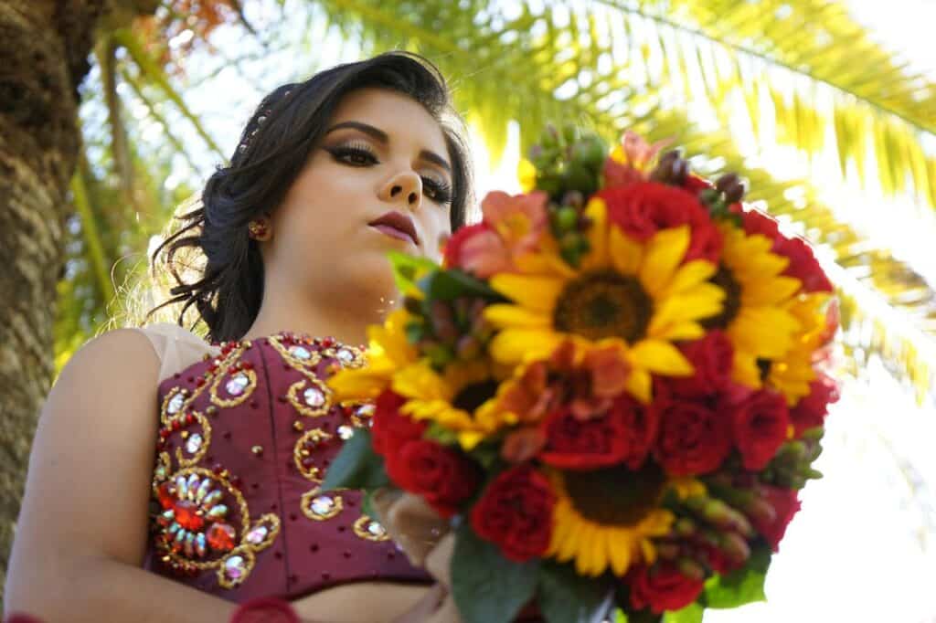 Photo by Becerra Govea Photo: https://www.pexels.com/photo/a-woman-in-red-gown-holding-a-bouquet-of-flowers-5934923/ -- teen celebration