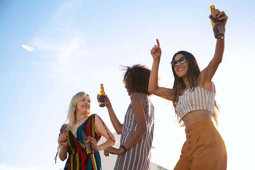 Photo by Kampus Production: https://www.pexels.com/photo/delighted-friends-having-drinks-and-dancing-on-sunny-terrace-5935207/ -- summer party