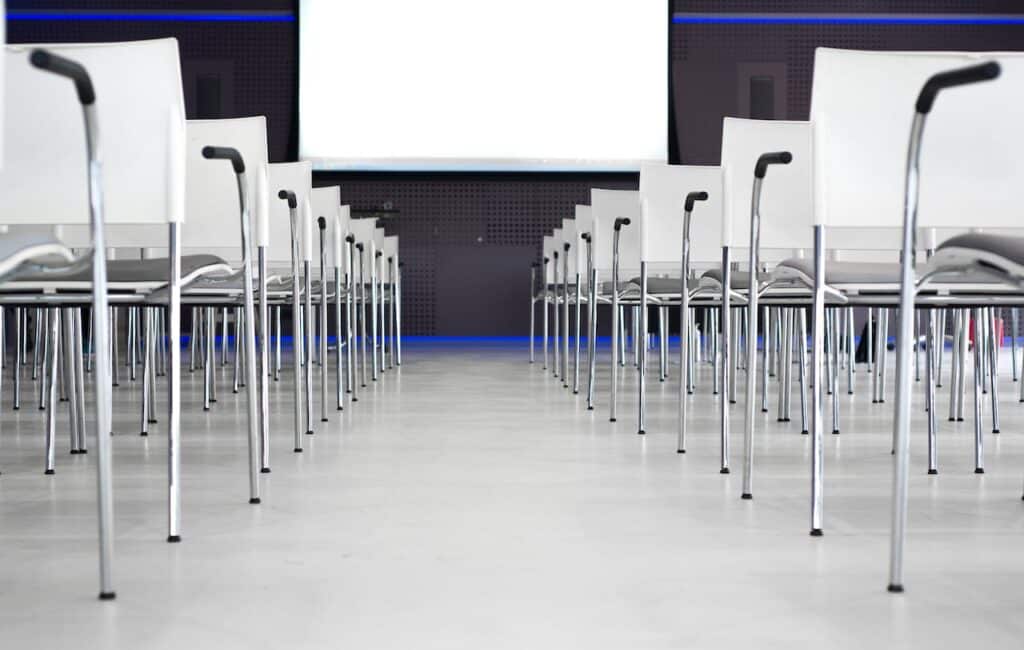 Photo by Skitterphoto: https://www.pexels.com/photo/low-angle-photography-of-pile-of-stainless-steel-chairs-with-hanging-projector-canvas-691485/ -- event