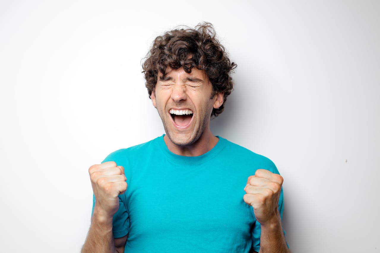 Photo by Andrea Piacquadio: https://www.pexels.com/photo/portrait-photo-of-excited-man-in-blue-t-shirt-standing-in-front-of-white-background-3768724/ -- team-building excitement