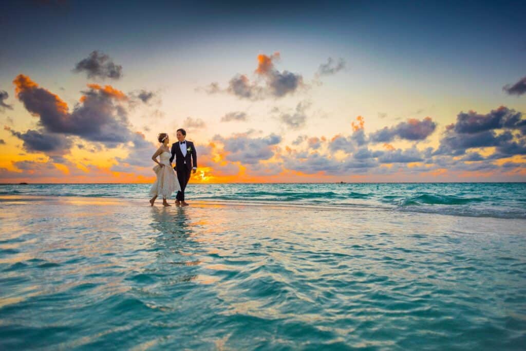 Photo by Asad Photo Maldives: https://www.pexels.com/photo/man-and-woman-walking-of-body-of-water-1024993/ -- anniversary wedding couple