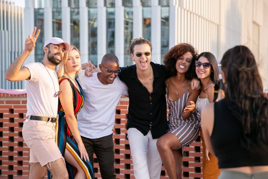 Photo by Kampus Production: https://www.pexels.com/photo/faceless-lady-taking-photo-of-positive-diverse-millennials-during-open-air-party-5935257/ -- summer party