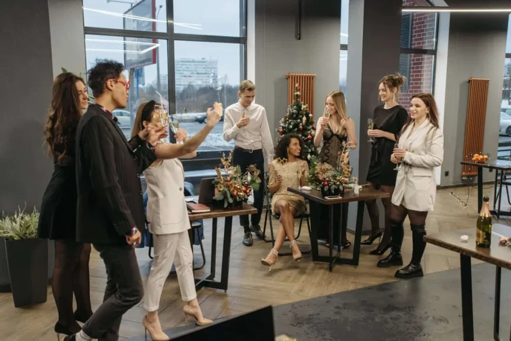 Photo by Pavel Danilyuk: https://www.pexels.com/photo/people-having-a-christmas-party-in-the-office-6405679/ -- company holiday party