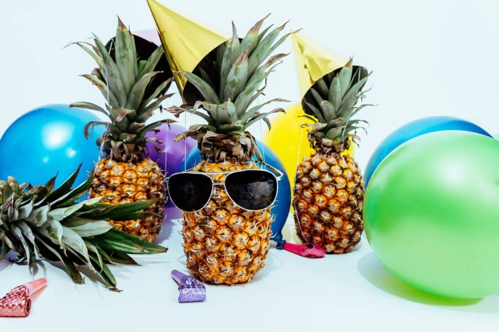 Photo by Pineapple Supply Co.: https://www.pexels.com/photo/photo-of-three-pineapples-surrounded-by-balloons-1071882/ -- summer office party swag favors