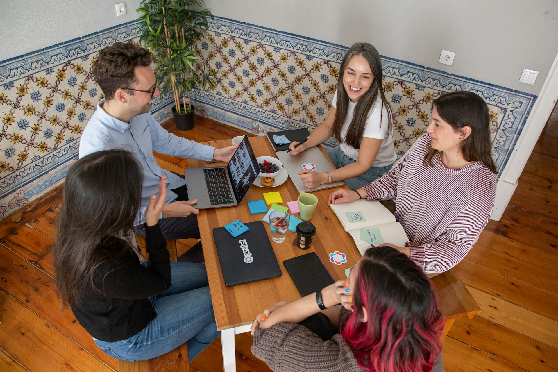 Image title: corporate events Image alt-title: A group of employees sitting around a wooden table. Image URL: https://unsplash.com/photos/a-group-of-people-sitting-around-a-wooden-table-e5ob6fBTi64 