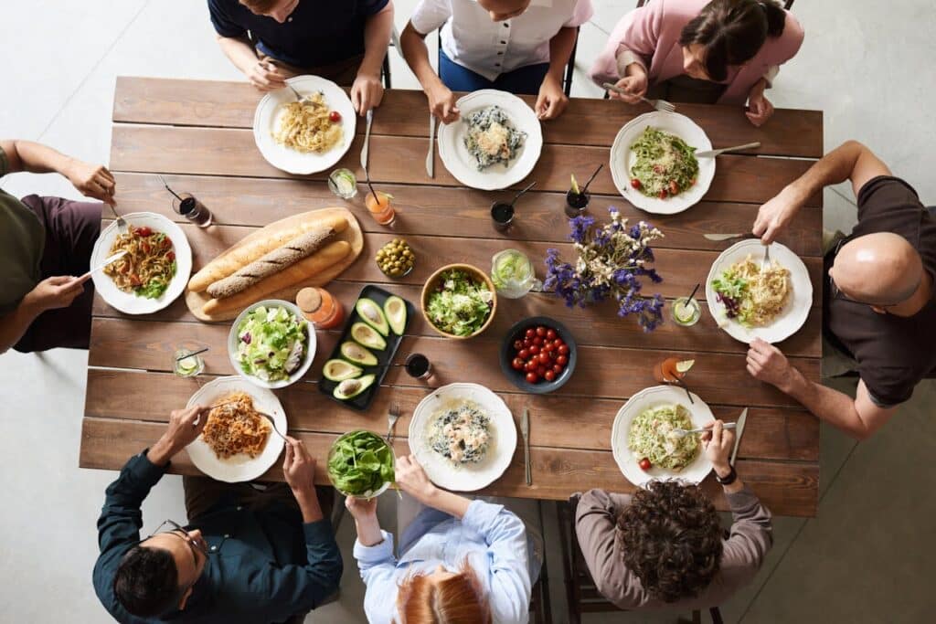 Photo by fauxels: https://www.pexels.com/photo/group-of-people-eating-together-3184195/ -- new york dinner party