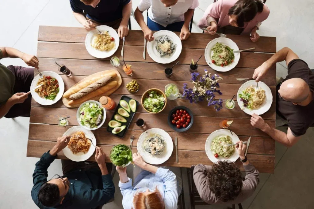 Photo by fauxels: https://www.pexels.com/photo/group-of-people-eating-together-3184195/ -- new york dinner party