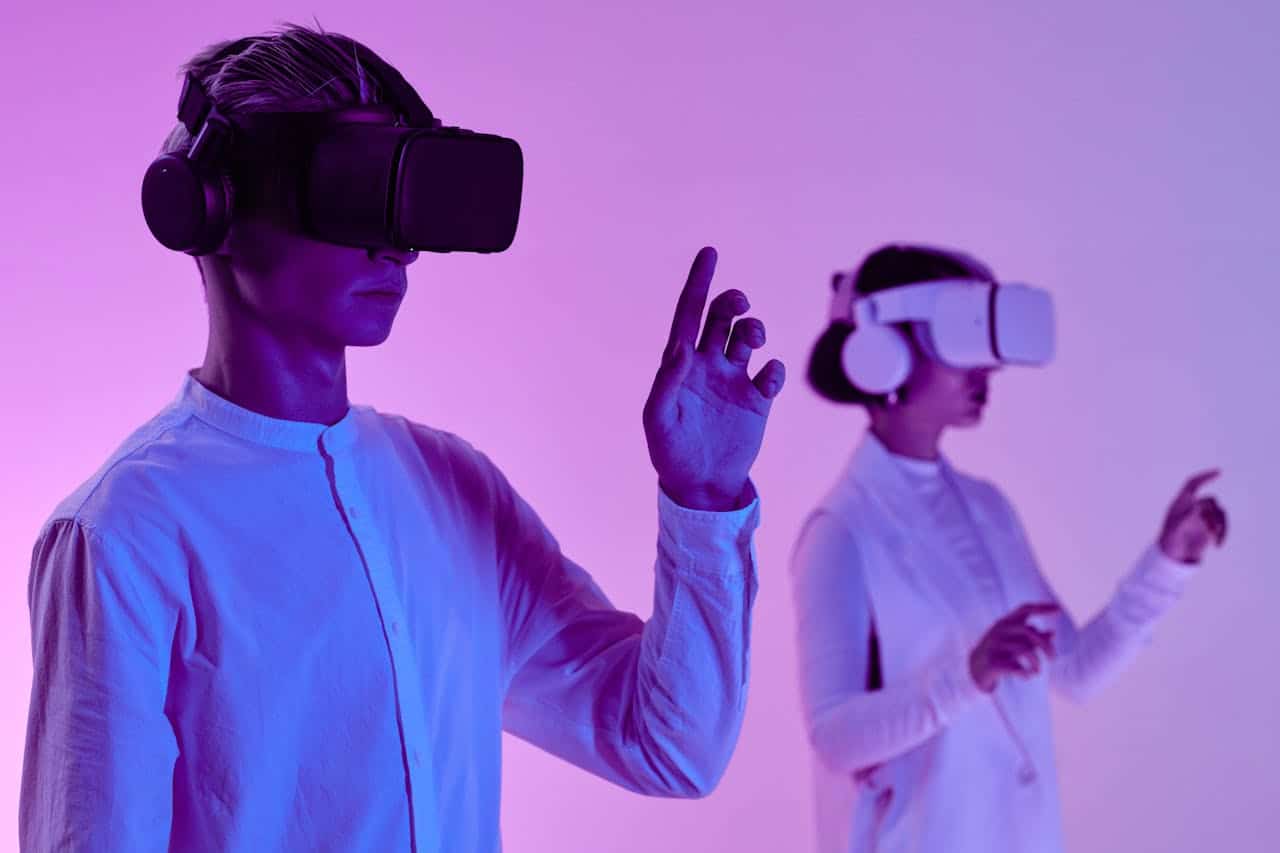 Photo by Michelangelo Buonarroti: https://www.pexels.com/photo/man-and-woman-in-vr-goggles-and-headphone-standing-in-studio-in-purple-lighting-8728562/