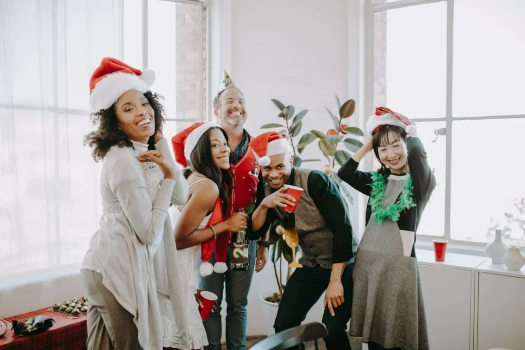 IMAGE URL: https://www.pexels.com/photo/friends-celebrating-christmas-6518892/ -- corporate holiday party