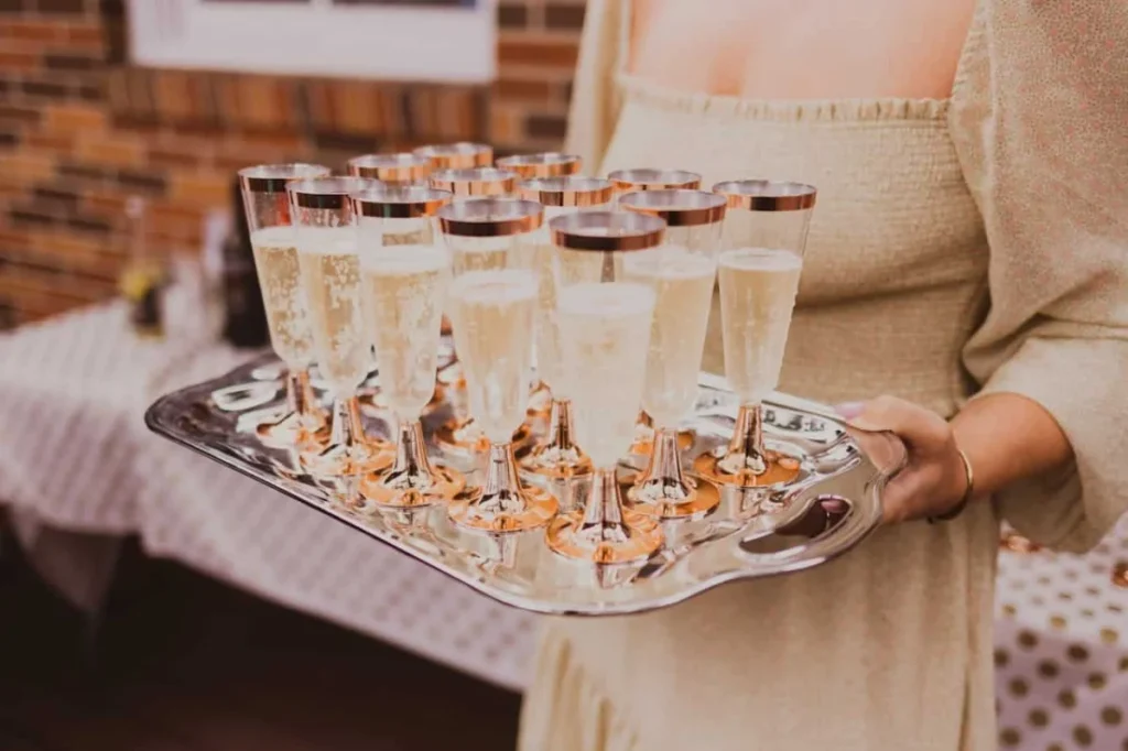 Photo by Wendy Wei: https://www.pexels.com/photo/crop-woman-with-tray-of-champagne-glasses-5306739/ -- party drinks