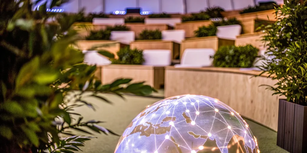 Hybrid event setup with tiered seating and digital globe centerpiece.