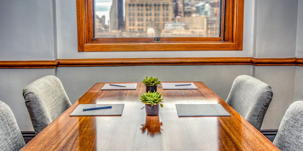Team planning meeting essentials: Table, notepads, pens, and plants.