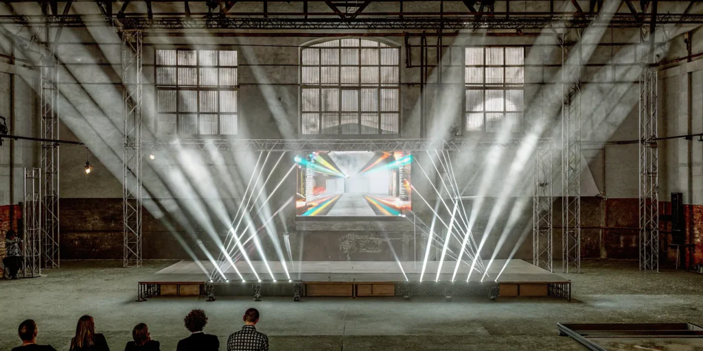 Hybrid event setup with audience and digital screen.
