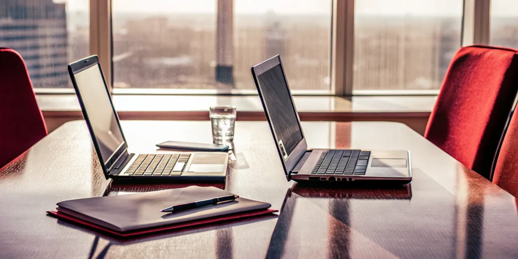 Corporate meeting setup with laptops and materials.