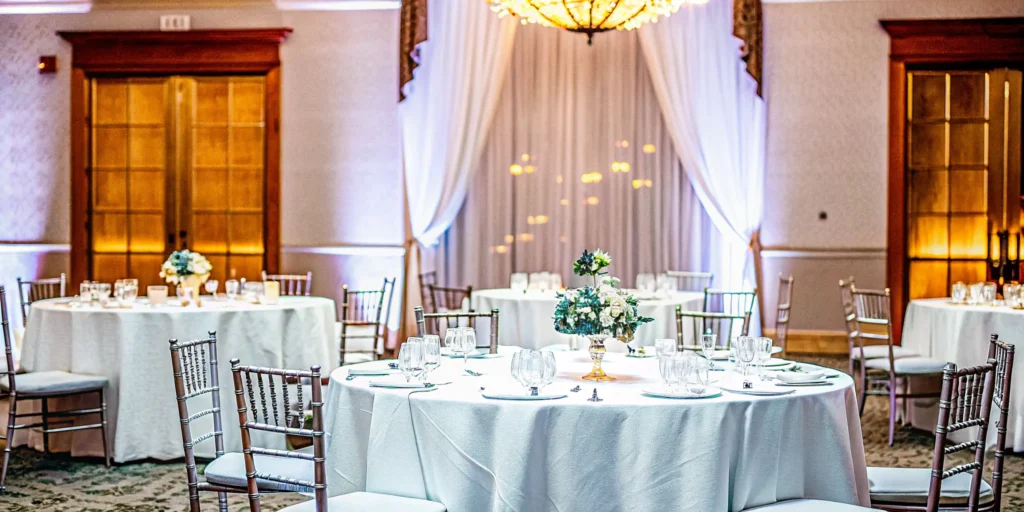 Professional conference and event planning services for an elegant setup with decorated round tables.