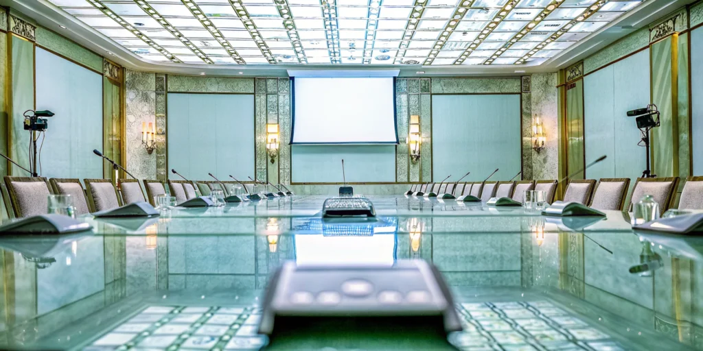 A hybrid event production company managing a live event with professional cameras, audio, and a large screen.