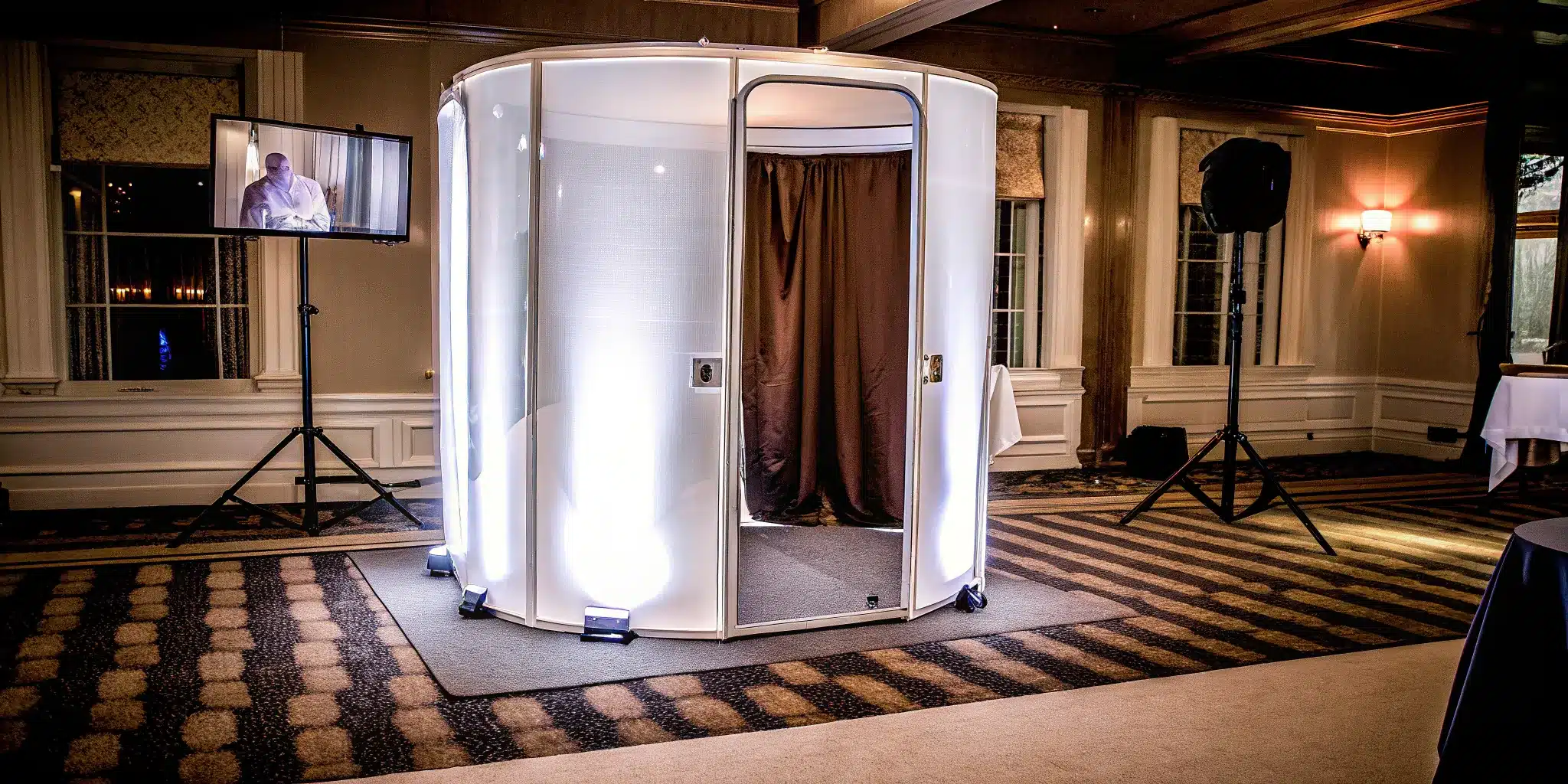 A 360 photo booth with a rotating camera arm and bright LED lights ready for an event.