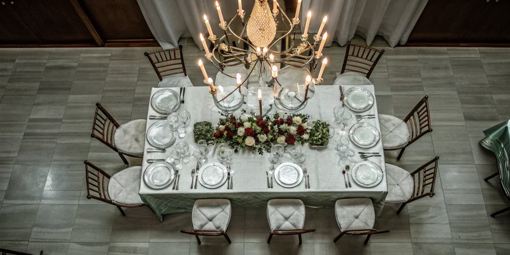 An elegant dining table set for a gala vs a banquet, with a floral centerpiece.