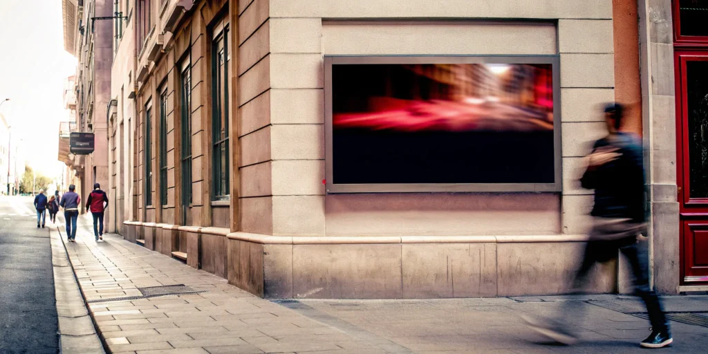 Outdoor digital signage on a city wall engaging pedestrians.