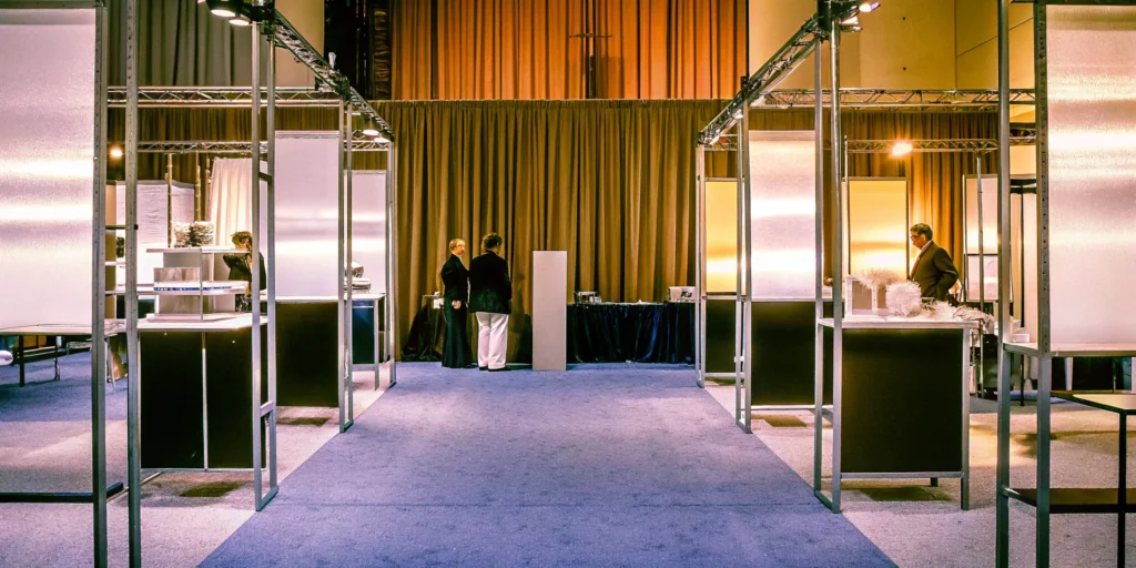 A well-managed trade show floor with professional staff engaging visitors at modern, organized booths.