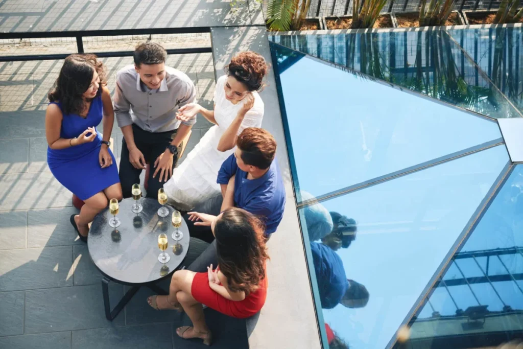 Group of friends drinking champagne chat talking at party, view from above