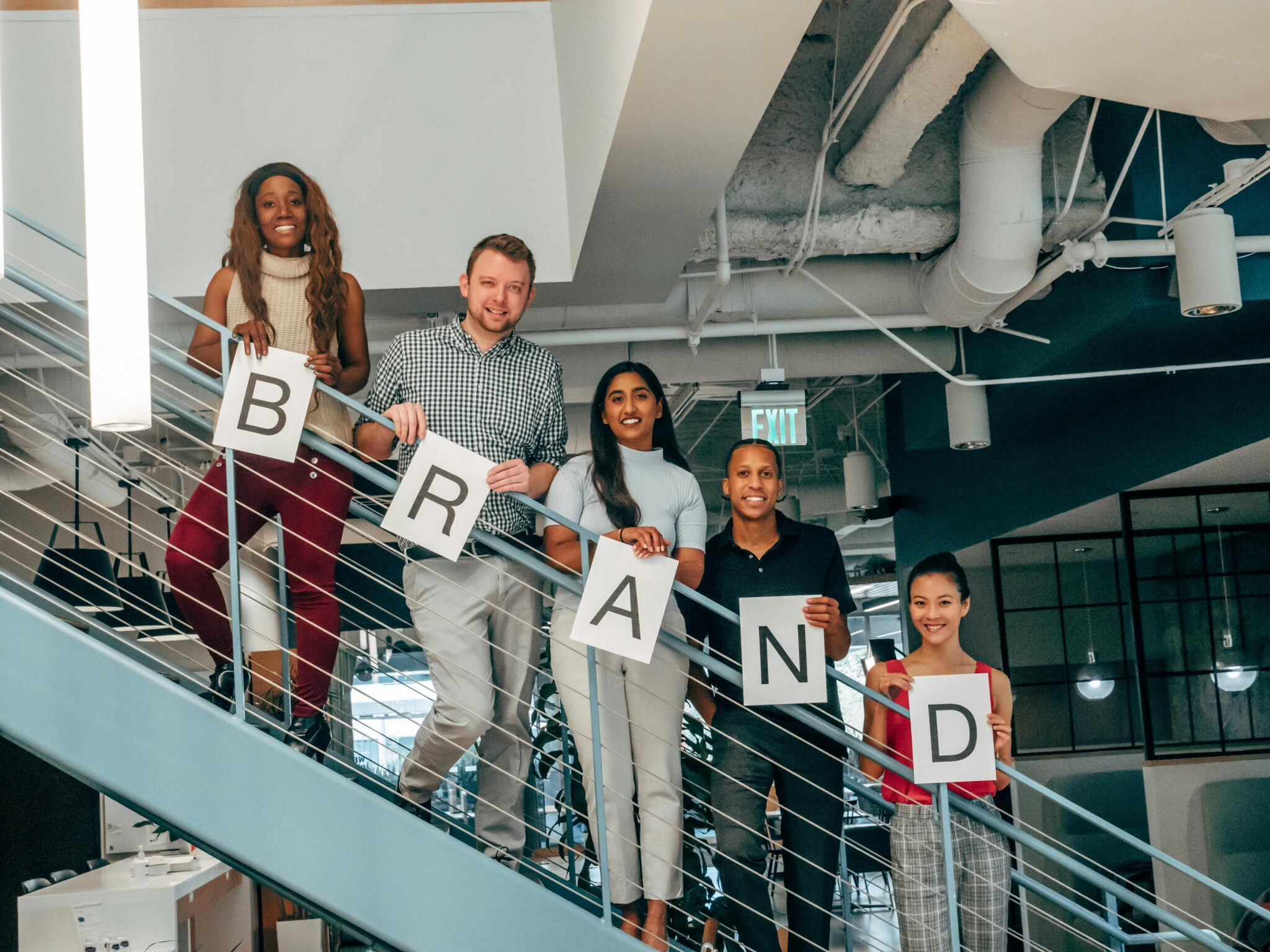 Photo by Kindel Media: https://www.pexels.com/photo/happy-coworkers-standing-on-a-stairway-7688464/