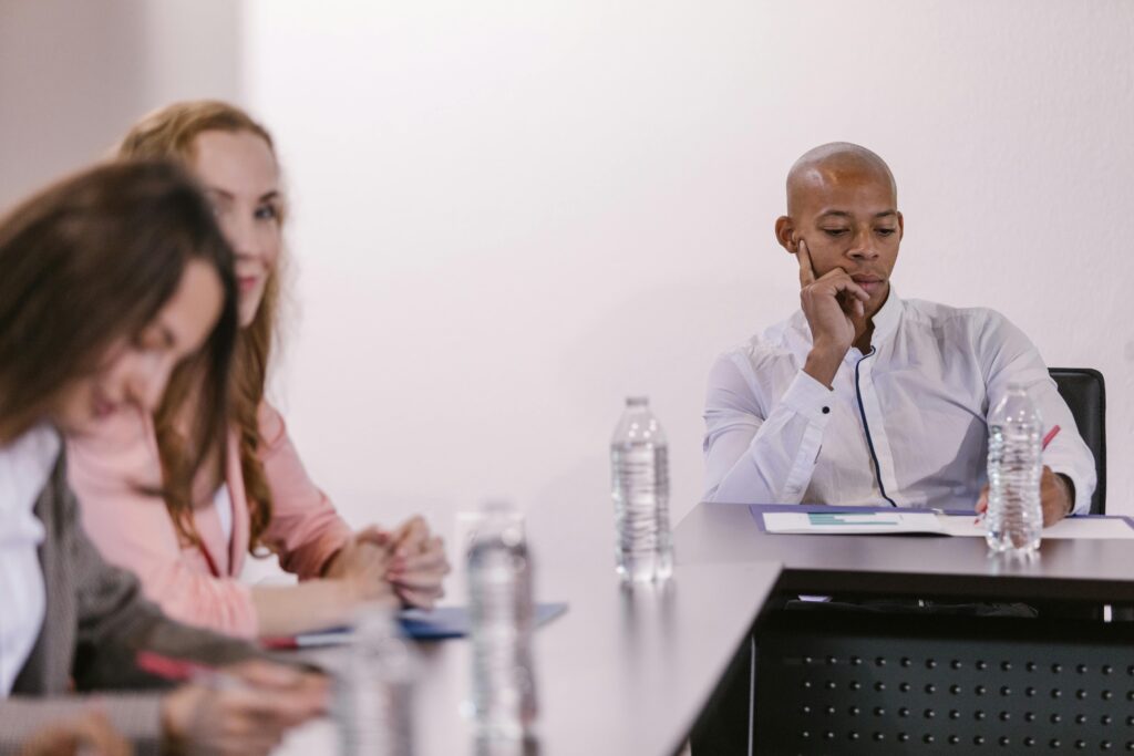 https://www.pexels.com/photo/people-sitting-at-a-table-on-a-conference-7647952/