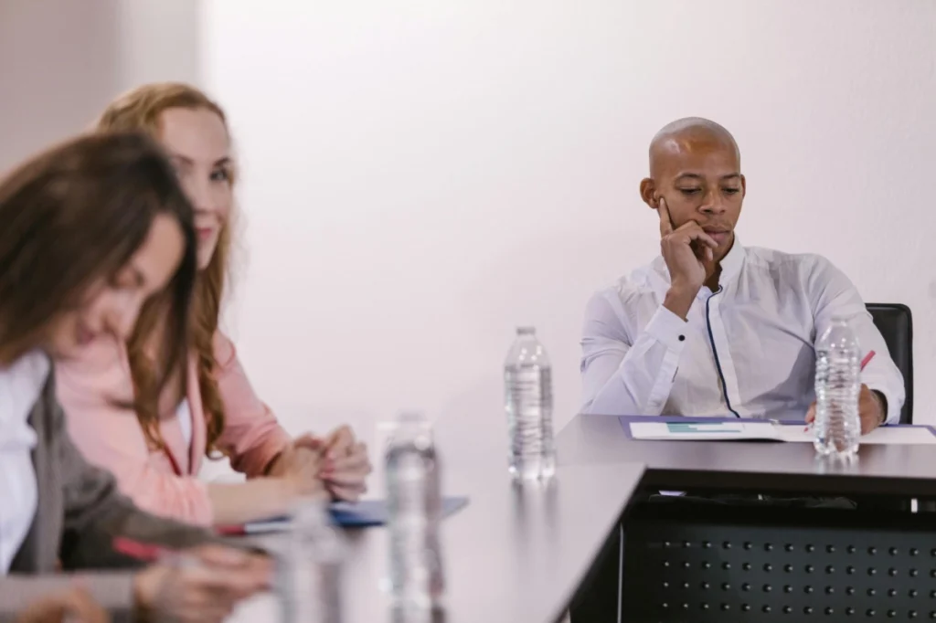 https://www.pexels.com/photo/people-sitting-at-a-table-on-a-conference-7647952/