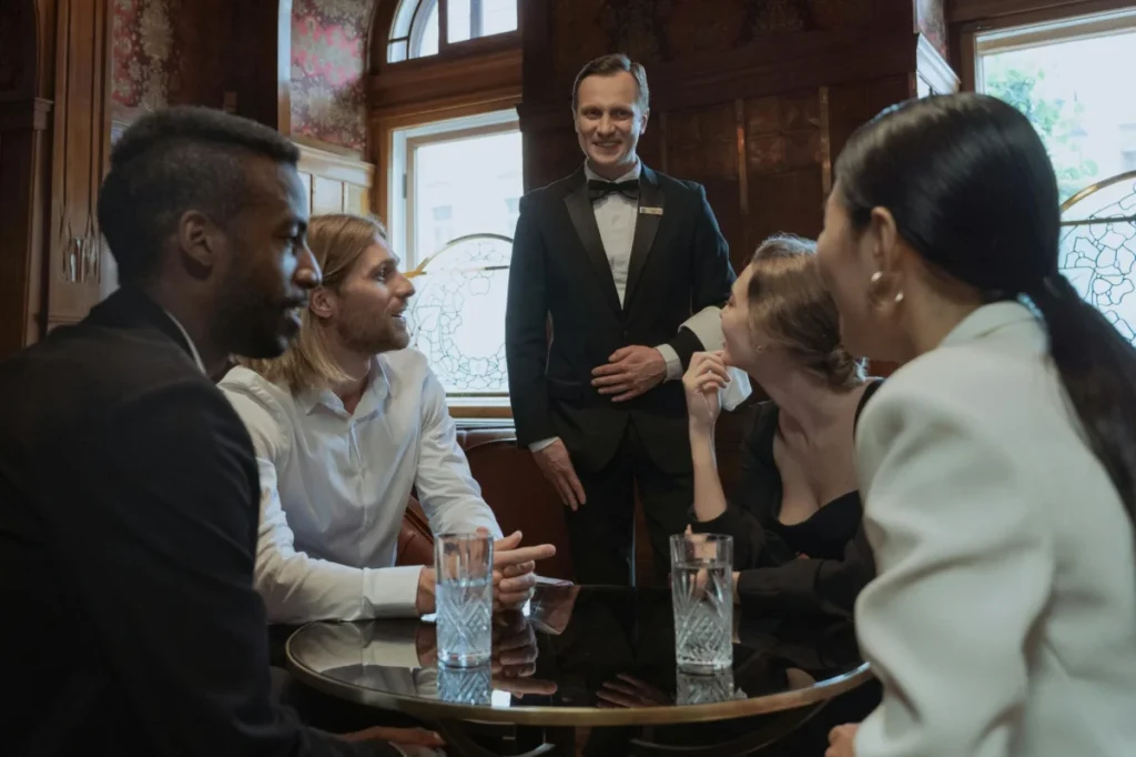 Photo by Ron Lach : https://www.pexels.com/photo/photo-of-a-group-of-friends-ordering-from-a-waiter-8921553/