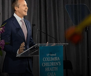 Speaker delivering remarks at a charity gala organized by EMRG Media in New York City.