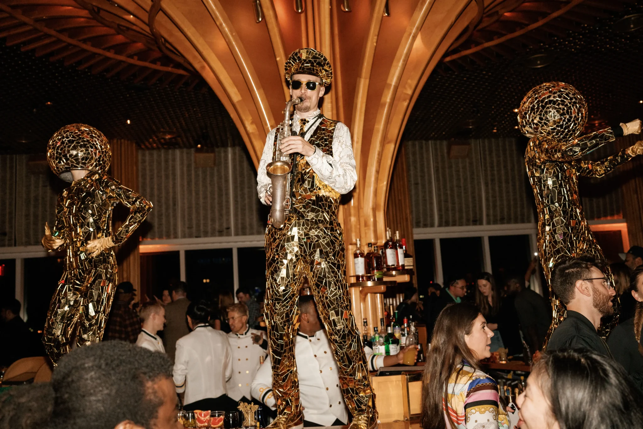 Saxophone performer in a gold mosaic costume entertaining guests at a NYC gala, photographed by EMRG Media