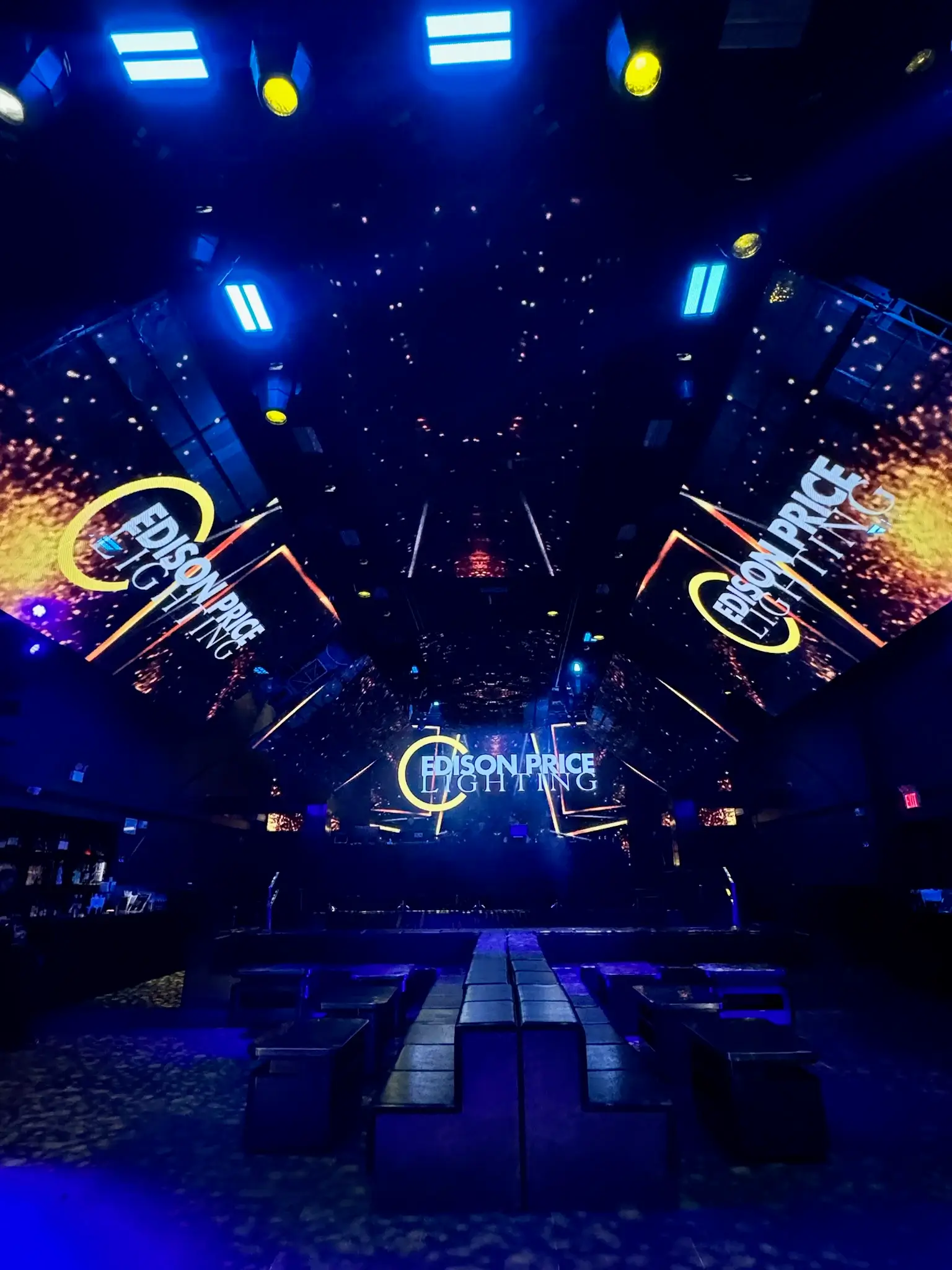Edison Price Lighting branded stage with LED ceiling panels and spark effects at a NYC event venue, EMRG Media