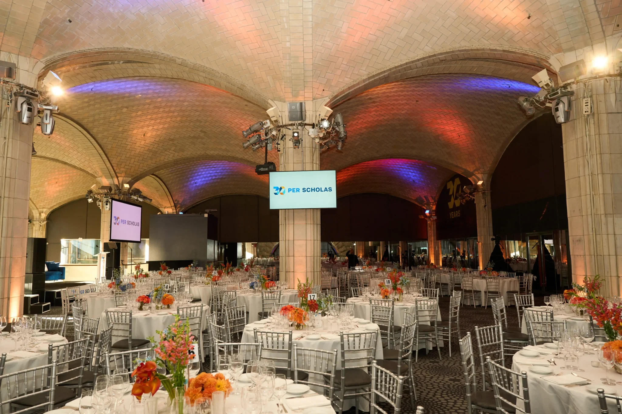 Per Scholas gala setup under a vaulted brick ceiling with colorful uplighting at a NYC venue, EMRG Media