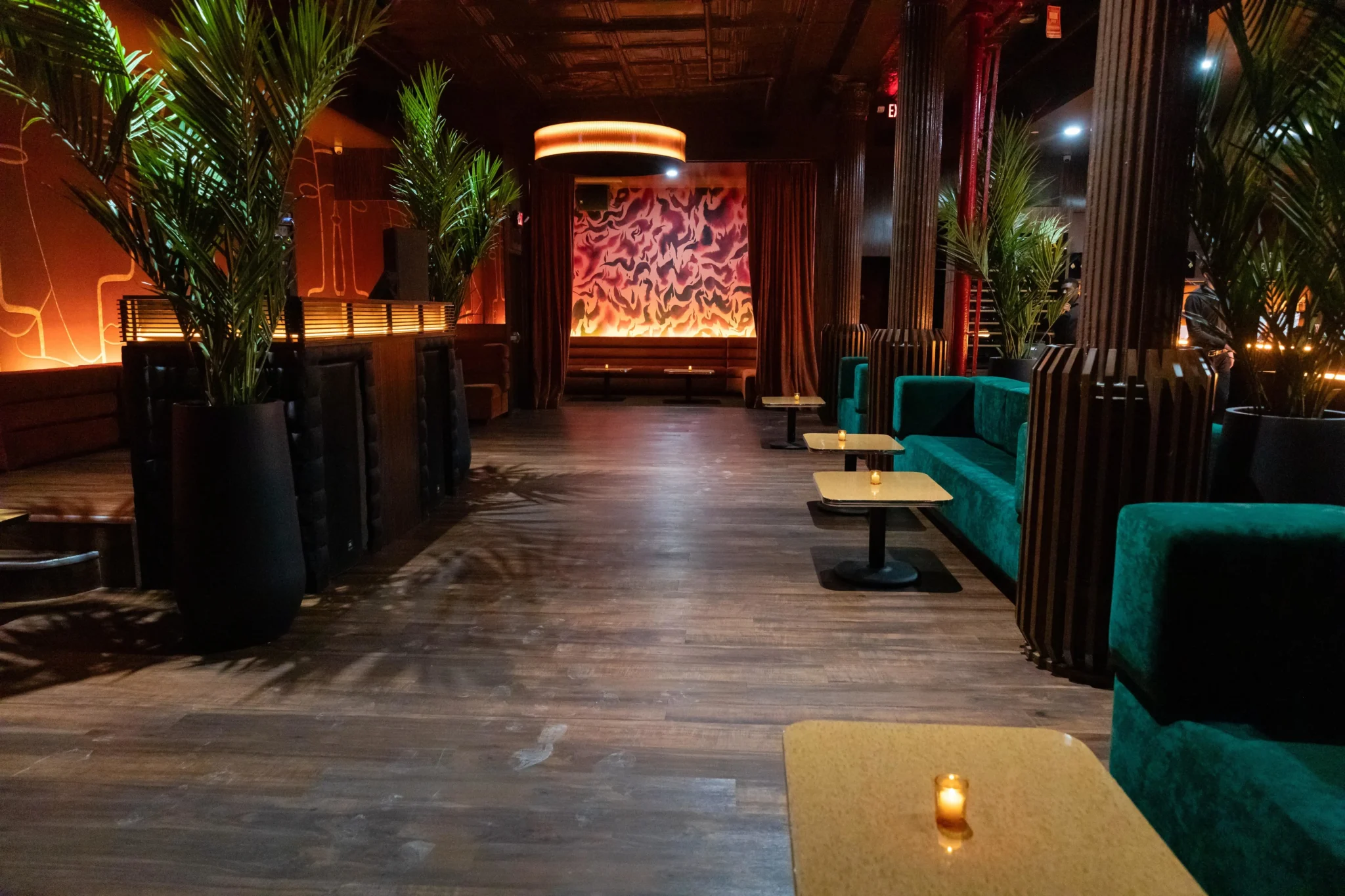 Warm-toned NYC lounge interior with teal booth seating and abstract fire mural, EMRG Media