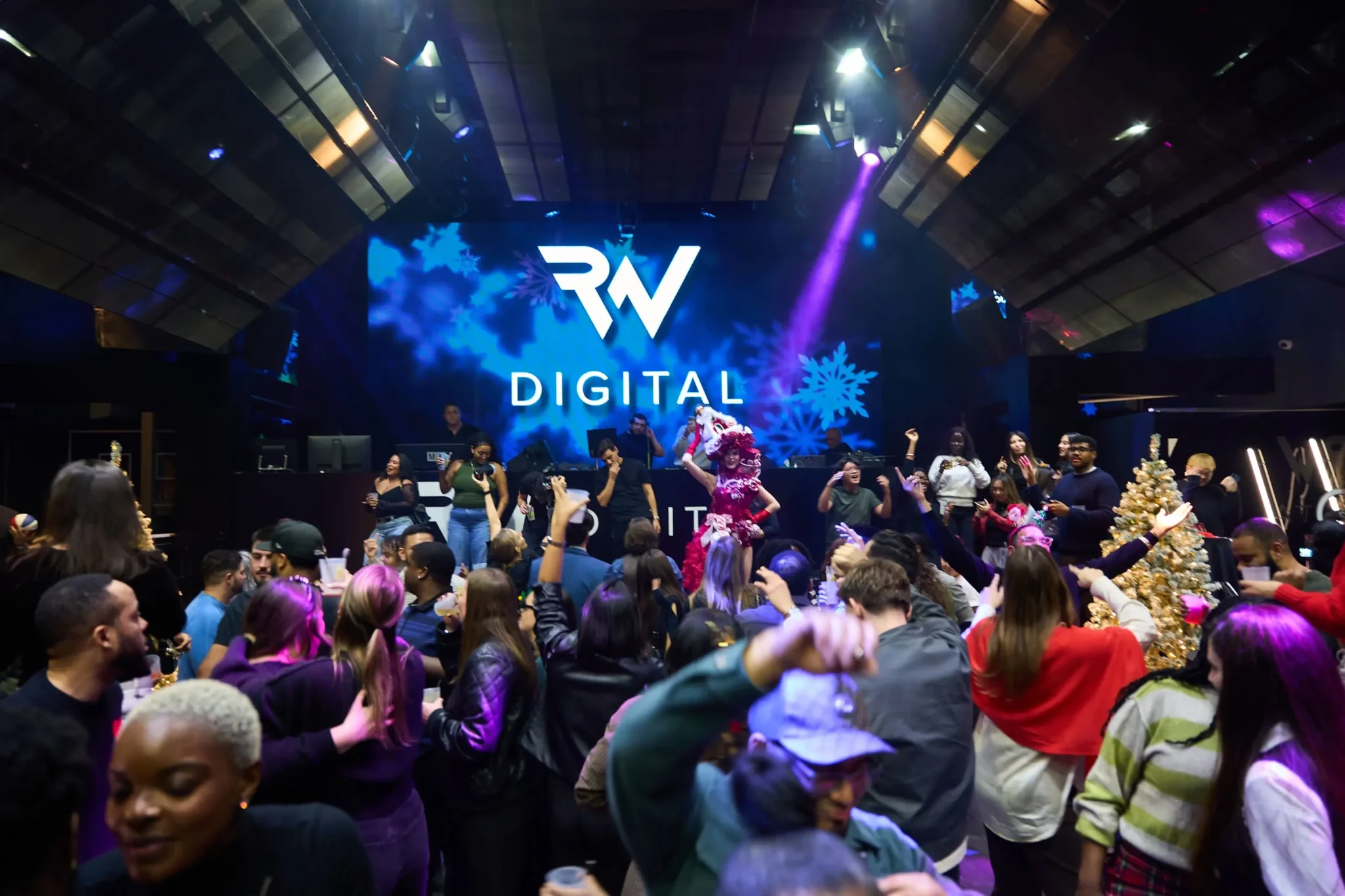 Costumed performer dancing above the crowd at RW Digital's branded NYC holiday party, EMRG Media