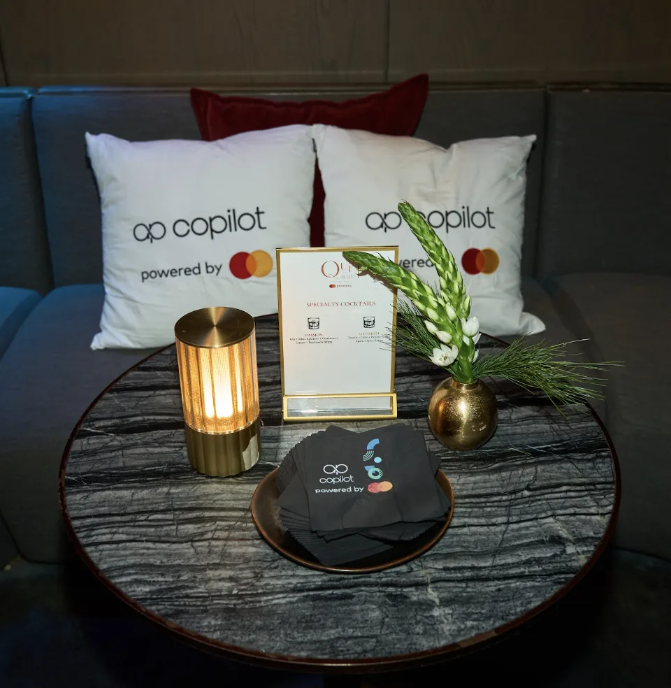 Copilot branded pillows and cocktail napkins by Mastercard at a NYC lounge activation, EMRG Media