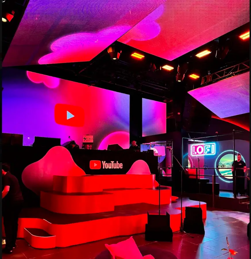 YouTube branded stage set with red curved seating and LED backdrop, stage design by EMRG Media